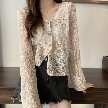 SheerCharm lace sun shirt with long sleeves and a V-neck, styled over a black skirt.