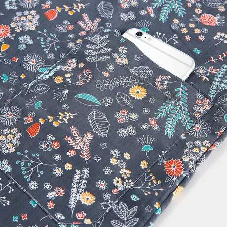 Navy blue nurse scrub with floral patterns and a pocket, ideal for medical professionals and beauty salons.