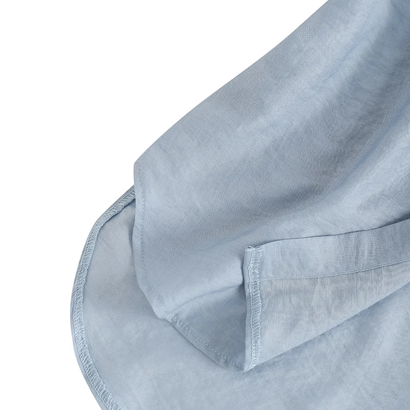 Close-up of soft blue fabric illustrating the breathable texture of ZanzeaEase™ oversized summer blouse.