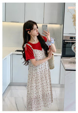 Woman modeling a floral two-piece maternity skirt with contrasting red top in modern kitchen.