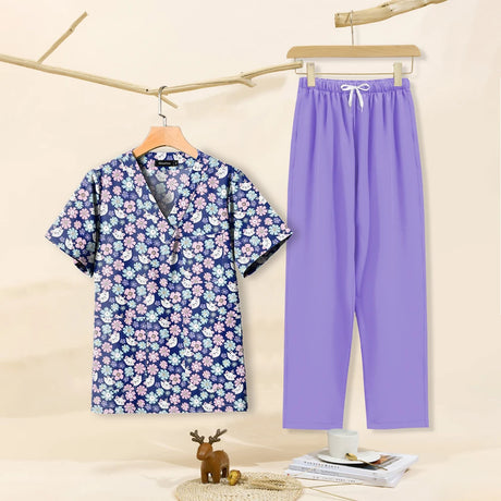 Cartoon print dental scrubs set for women featuring a floral top and purple pants, ideal for pet grooming.