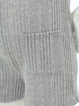 Close-up of a sleeveless ribbed maternity jumpsuit showing textured fabric and side pockets in gray.