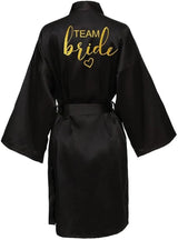 Black satin kimono robe with gold 'TEAM Bride' lettering, perfect for bridal parties and celebrations.