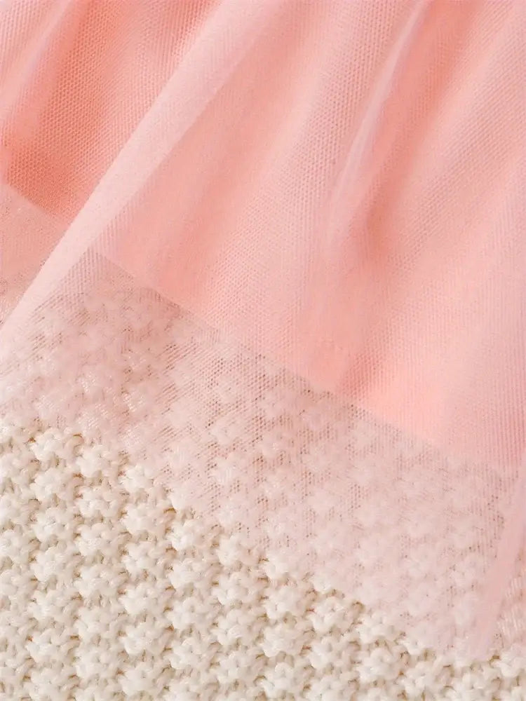 Delicate pink tulle overlay on soft white knitted fabric, perfect for a newborn girls dress.