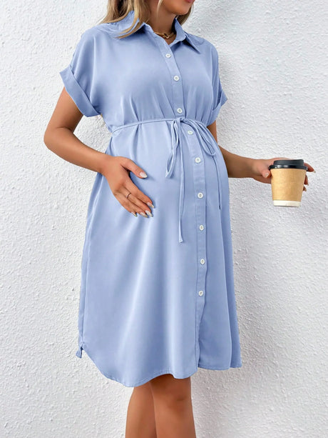 Casual summer maternity dress in light blue featuring a button-down design, short sleeves, and a tied waist.