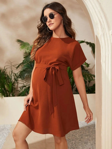 Maternity bat-sleeve tunic dress in rust color, knee-length, perfect for summer photoshoots and stylish comfort.