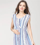 Model wearing a sleeveless round neck cotton nursing dress in blue striped pattern, perfect for summer maternity.