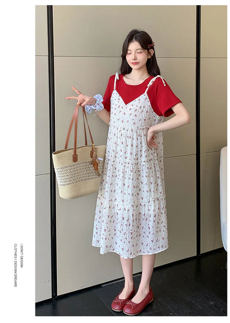 Model wearing a floral two-piece maternity skirt with a red top, showcasing a stylish summer look.