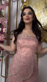 Elegant pink beaded engagement gown with tiered skirt, showcasing a strapless neckline and shimmering embellishments.