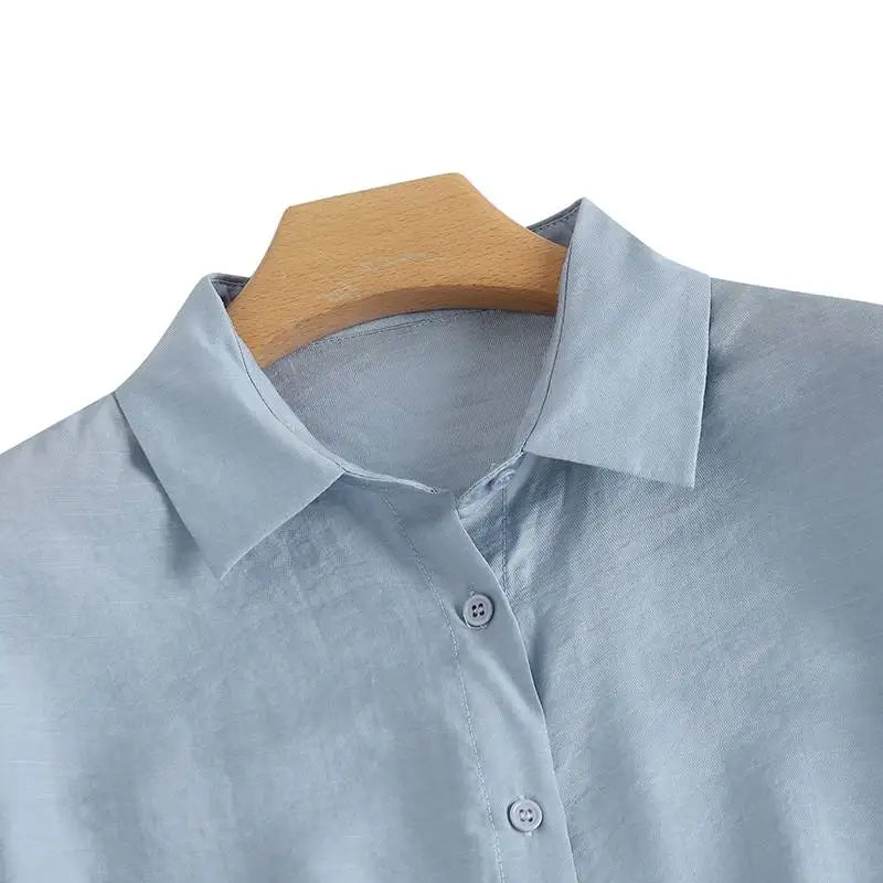 Close-up of ZanzeaEase™ oversized summer blouse collar in light blue, featuring button-down design and relaxed fit.