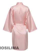 Back view of a knee-length pink satin kimono robe with wide sleeves and a tie belt.