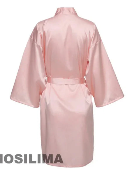 Back view of a knee-length pink satin kimono robe with wide sleeves and a tie belt.