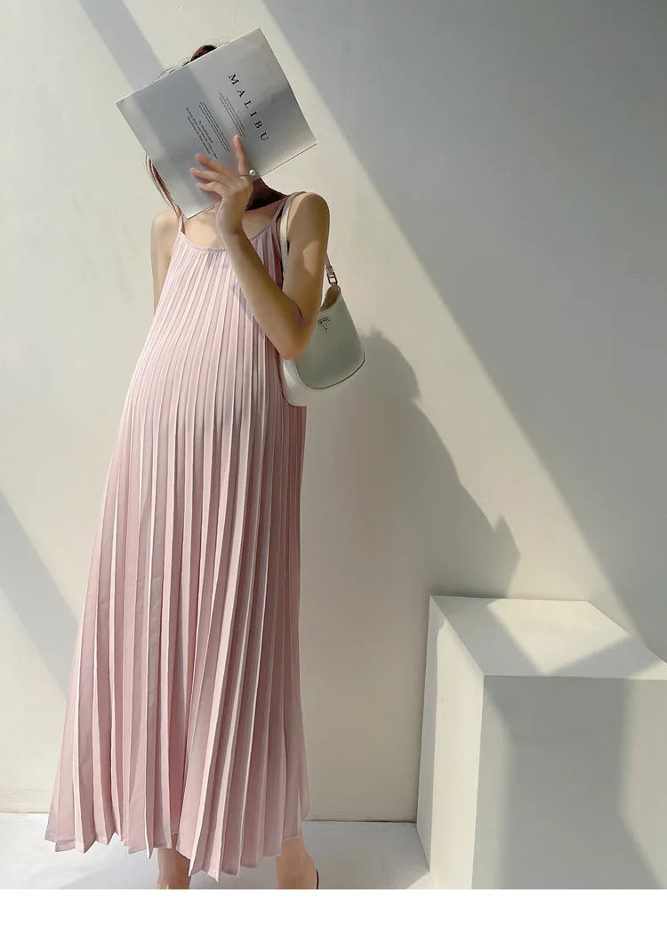 Pleated chiffon maternity dress in pastel pink, mid-calf length, perfect for summer styling.