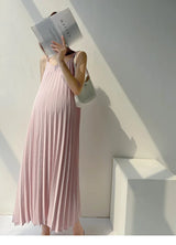 Pleated chiffon maternity dress in pastel pink, mid-calf length, perfect for summer styling.