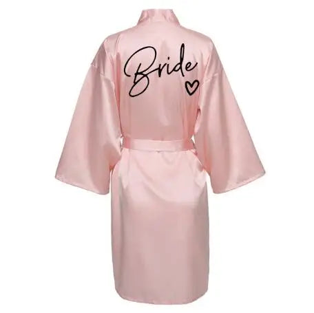 Back view of a pink satin robe with the word 'Bride' printed in black, perfect for wedding festivities.