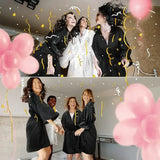 Four women in matching robes celebrating with balloons and confetti, perfect for a bridesmaid occasion.