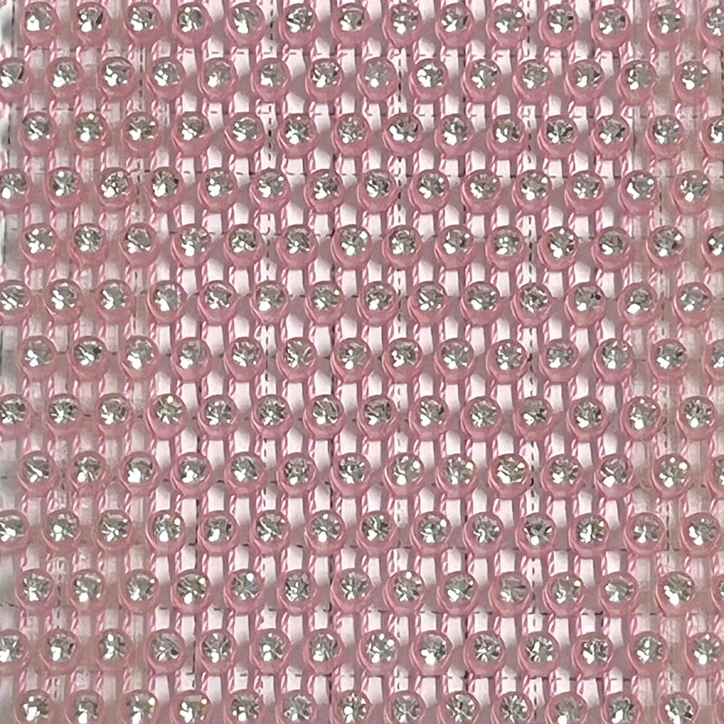 Close-up of shimmering pink mesh fabric with rhinestones, ideal for glamorous party wear.