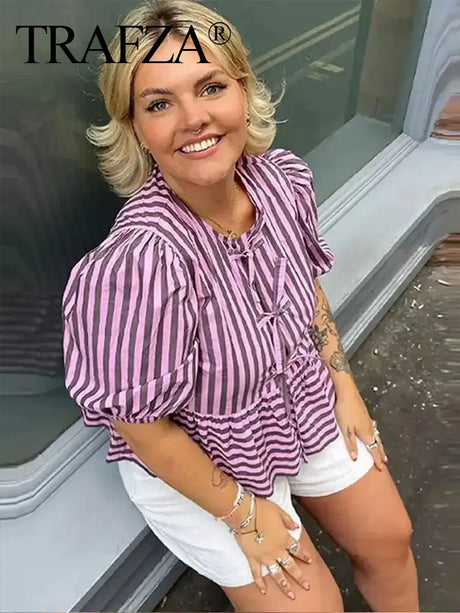 Woman wearing TRAFZA striped lace-up blouse, styled with white shorts, showcasing vintage short sleeve elegance.
