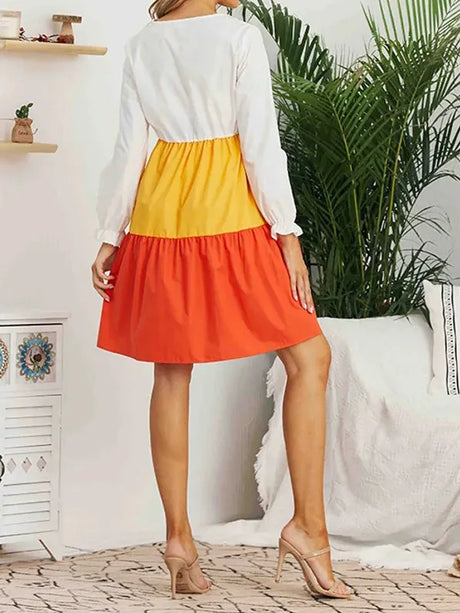 Back view of a colorful maternity dress in orange, yellow, and white, perfect for summer and breastfeeding.