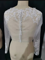 Back view of a Lace Bridal Bolero from Noble Weiss, featuring long sleeves and intricate floral appliqué details.