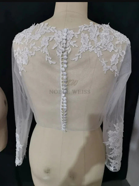 Back view of a Lace Bridal Bolero from Noble Weiss, featuring long sleeves and intricate floral appliqué details.