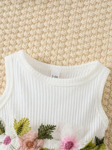 Close-up of a white newborn dress with floral embroidery, perfect for summer baby girls aged 0-1 year.