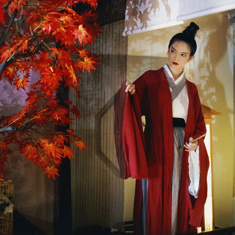 Swordsman Hanfu costume in wine red worn by a woman, set against a backdrop of vibrant autumn leaves.