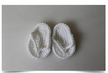 Cute white knitted baby flip flops perfect for toddlers, soft and comfortable for little feet.