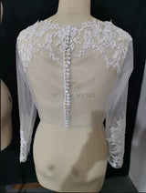 Lace bridal bolero by Noble Weiss, featuring intricate appliques and long sleeves, perfect for elegant wedding outfits.