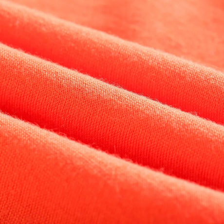 Close-up of soft, vibrant coral fabric showcasing texture and color for garment manufacturing.