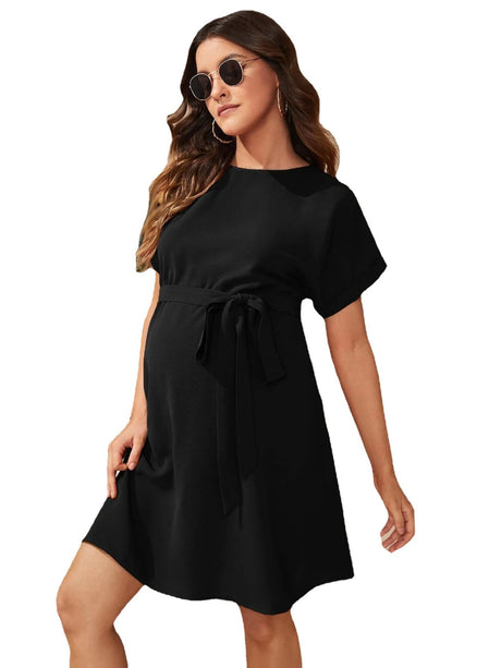 Bat-sleeve maternity tunic dress in black, featuring a boat neckline and tied waist, perfect for summer photo shoots.