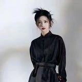 Woman in black traditional Hanfu outfit with a stylish hairstyle, showcasing elegance and cultural attire.
