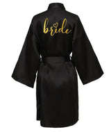 Black satin bride robe with gold lettering, perfect for wedding preparations and special occasions.