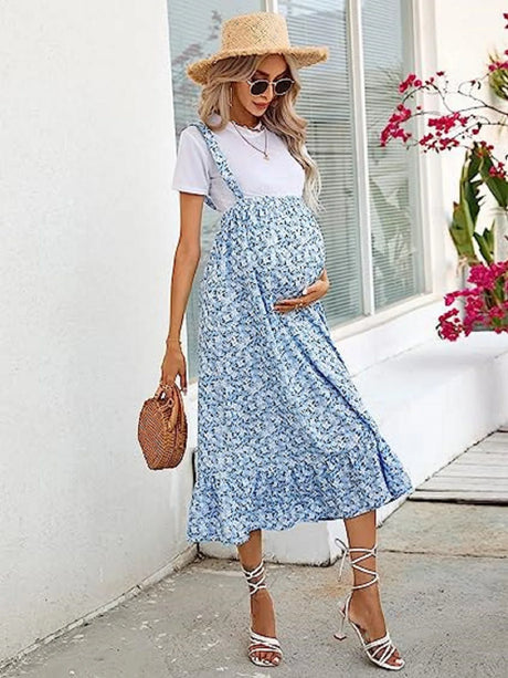 Stylish maternity dress for summer featuring floral pattern, comfortable fit, and paired with a straw hat and sandals.