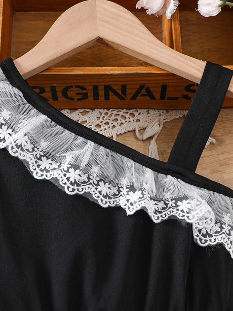 Close-up view of a toddler girl black summer dress with lace decoration and asymmetrical collar.