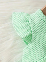Mint green baby girls dress detail with textured fabric and ruffled sleeves, perfect for summer outings.