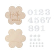 Wooden baby milestone flowers with engraved 'Hello World' and 'Month' text, and numeric and floral accent pieces.