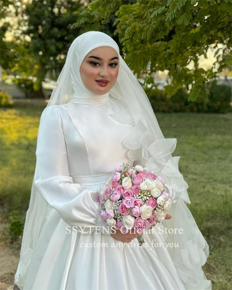 Elegant Muslim bride in satin A-line wedding dress with high collar and bouquet of pink roses.