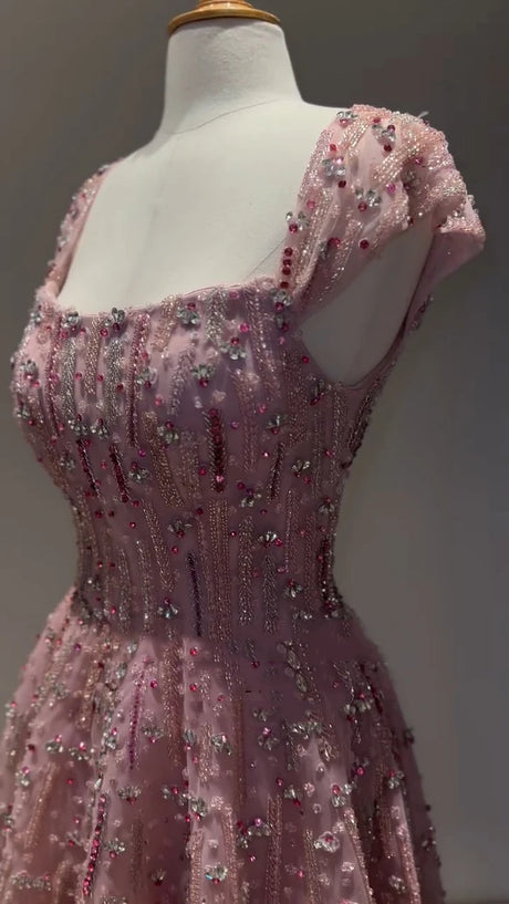 Close-up of a pink glitter crystal mermaid wedding gown with beaded detailing and cap sleeves.