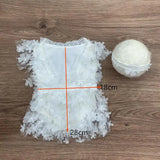 Newborn photography prop featuring a white floral romper and a soft ball, ideal for capturing sweet baby moments.