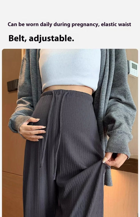 Woman showcasing adjustable elastic waist on wide-leg maternity pants, perfect for daily wear during pregnancy.