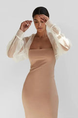 Model wearing a stylish black tulle bridal cape over a sleek fitted dress, showcasing elegant long sleeves for weddings.