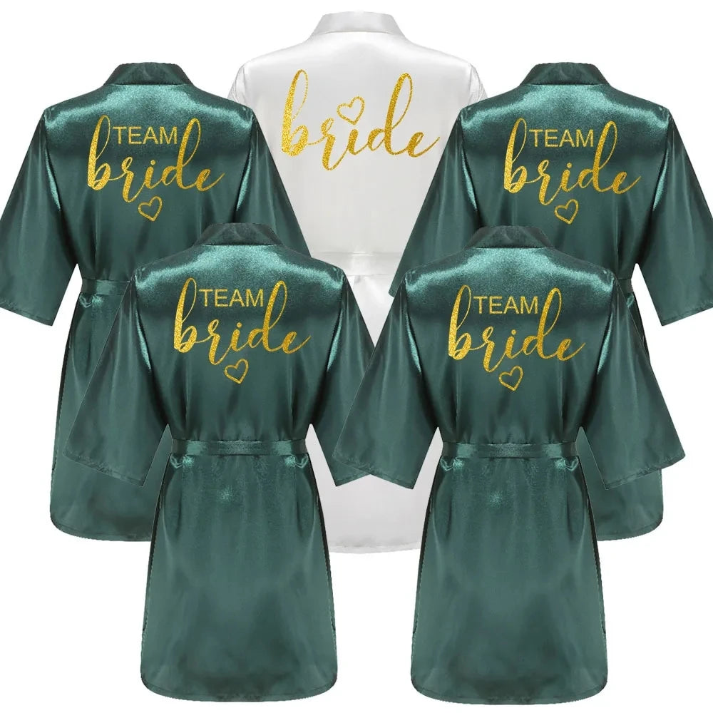 Gold and green satin bride and bridesmaid robes, featuring 'Team Bride' and 'Bride' lettering, perfect for wedding parties.