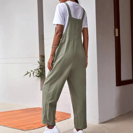 Woman wearing adjustable maternity overalls in olive green, showcasing a loose fit and casual style in a modern setting.