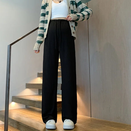 Wide-leg maternity pants in black, featuring a drawstring waist, styled with a cropped top and cozy cardigan.