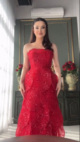 Model wearing a stunning red strapless engagement dress with layered beading detail, showcasing elegance and style.
