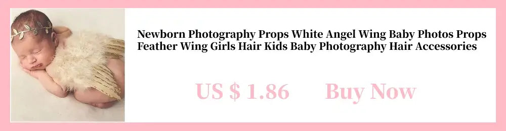 Newborn baby girl posing with white angel wing photography props, wearing hair accessories for adorable baby photos.