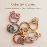 Colorful baby teether rings designed for visual development, featuring soft, safe silicone materials in various colors.