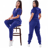 Women wearing breathable medical scrub sets in blue, showcasing short sleeves and comfortable fit, ideal for healthcare settings.