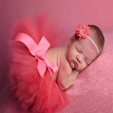 Newborn girl in a pink tutu skirt and headband, perfect for baby photography and special occasions.